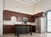 Thumbnail 43 of 55 - A kitchen with brown cabinets and a black island.