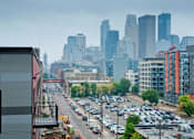 Thumbnail 31 of 55 - A city street with cars and buildings in the background.
