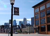 Thumbnail 52 of 55 - A street sign for the North Loop stands in front of a city skyline.