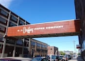 Thumbnail 49 of 55 - A street view of a Duffey Paper Company building with cars parked in front.