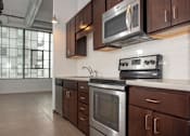 Thumbnail 25 of 44 - A kitchen with a stove, oven, and microwave.at Gurley Lofts, Minnesota