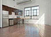 Thumbnail 28 of 44 - A kitchen with brown cabinets and a stainless steel refrigerator.at Gurley Lofts, Minnesota