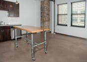 Thumbnail 42 of 44 - A kitchen with a table and a brick wall.at Gurley Lofts, Minnesota, 55401