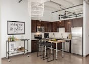 Thumbnail 5 of 44 - A kitchen with a fridge, stove, and bar cart.at Gurley Lofts, Minnesota