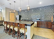 Thumbnail 47 of 73 - A kitchen with a bar area and chairs.at Third North Apartments, Minneapolis, MN