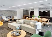 Thumbnail 28 of 77 - A modern living room with a grey sofa and a wooden coffee table.at Viridium Apartments, Minneapolis, MN 