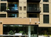 Thumbnail 42 of 77 - A patio with a table and chairs is in front of a building.at Viridium Apartments, Minnesota 