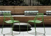 Thumbnail 43 of 77 - Two green chairs are placed in front of a wooden bench.at Viridium Apartments, Minneapolis 