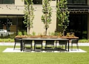 Thumbnail 49 of 77 - A table and chairs are set up on a lawn in front of a building.at Viridium Apartments, Minneapolis, MN 