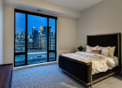 Thumbnail 62 of 77 - A bedroom with a large bed and a view of the city.at Viridium Apartments, Minnesota, 55401