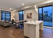Thumbnail 63 of 77 - A modern kitchen with a dining table and chairs.at Viridium Apartments, Minneapolis, 55401 
