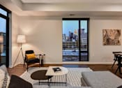 Thumbnail 65 of 77 - A living room with a view of the city through the windows.at Viridium Apartments, Minneapolis, MN 55401 