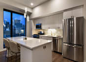 Thumbnail 66 of 77 - A modern kitchen with a large island and stainless steel appliances.at Viridium Apartments, Minneapolis, MN 