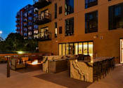 Thumbnail 73 of 77 - A patio area with a fire pit and seating area in front of a building.at Viridium Apartments, Minnesota 