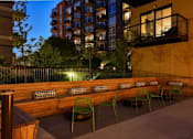 Thumbnail 74 of 77 - A patio with green chairs and a wooden bench.at Viridium Apartments, Minneapolis, 55401 