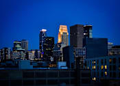 Thumbnail 77 of 77 - A city skyline at dusk with buildings illuminated against a darkening sky.at Viridium Apartments, Minnesota, 55401