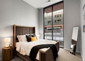 Thumbnail 8 of 77 - A bedroom with a large bed and a large window.at Viridium Apartments, Minneapolis, 55401 
