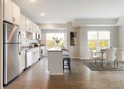 Thumbnail 28 of 80 - A modern kitchen with white cabinets and a large island at The Barnum Apartments, White Bear Lake, MN,  55110