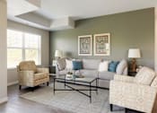 Thumbnail 31 of 80 - A living room with a sofa, two chairs, and a coffee table at The Barnum Apartments, White Bear Lake