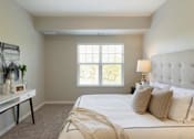 Thumbnail 33 of 80 - A bedroom with a large bed and a window with blinds at The Barnum Apartments, White Bear Lake