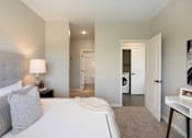 Thumbnail 34 of 80 - A bedroom with a large bed and a lamp on the nightstand at The Barnum Apartments, White Bear Lake, 55110
