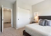 Thumbnail 38 of 80 - A bedroom with a large bed and a nightstand with a lamp at The Barnum Apartments, Minnesota, 55110