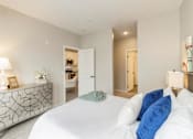 Thumbnail 50 of 80 - A bedroom with a large bed and a dresser with a lamp on it at The Barnum Apartments, White Bear Lake
