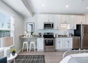 Thumbnail 53 of 80 - A kitchen with white cabinets and stainless steel appliances at The Barnum Apartments, White Bear Lake