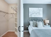 Thumbnail 57 of 80 - A bedroom with a bed, pillows, a lamp, and a painting on the wall at The Barnum Apartments, Minnesota, 55110