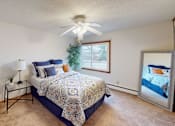 Thumbnail 5 of 12 - A bedroom with a bed, a ceiling fan, and a window.