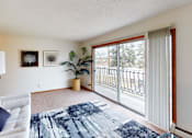 Thumbnail 7 of 12 - A living room with a grey couch and a blue patterned rug.