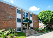 Thumbnail 2 of 12 - A red brick building with a green awning and the number 50 on it.
