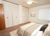 Thumbnail 8 of 12 - A bedroom with a large bed and a ceiling fan.