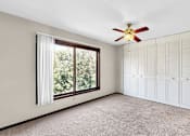 Thumbnail 5 of 28 - A room with a ceiling fan and a window with curtains.