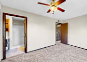 Thumbnail 6 of 28 - A room with a ceiling fan and carpeted floor.