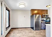 Thumbnail 2 of 28 - A kitchen with a refrigerator, microwave, and oven.