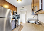 Thumbnail 1 of 28 - A kitchen with a stainless steel refrigerator and a microwave above the stove.