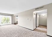 Thumbnail 4 of 28 - A spacious room with a carpeted floor and a sliding glass door leading to a balcony.