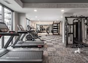 Thumbnail 21 of 92 - A gym with treadmills, weights, and exercise equipment.
