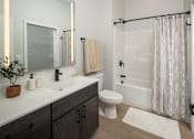 Thumbnail 36 of 92 - A bathroom with a white toilet, sink, and shower.