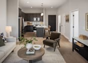 Thumbnail 34 of 92 - A modern living room with a grey sofa, a coffee table, and a kitchen in the background.