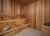 Thumbnail 24 of 92 - A wooden sauna with a bench and a container of stones.