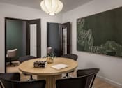 Thumbnail 17 of 92 - A conference room with a round table surrounded by chairs.