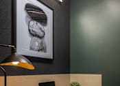 Thumbnail 18 of 92 - A modern workspace with a laptop, lamp, and a framed picture on the wall.