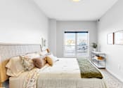 Thumbnail 53 of 92 - A bedroom with a large bed and a window overlooking a parking lot.