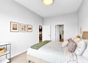 Thumbnail 54 of 92 - A bedroom with a bed, pillows, and pictures on the wall.
