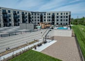 Thumbnail 58 of 92 - A large apartment complex with a pool and a playground.