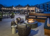 Thumbnail 63 of 92 - A patio with a fire pit and seating area.