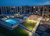Thumbnail 68 of 92 - A large building with a pool and a lawn area.
