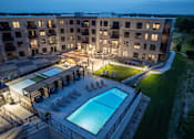 Thumbnail 65 of 92 - A large apartment complex with a pool and lounge area.